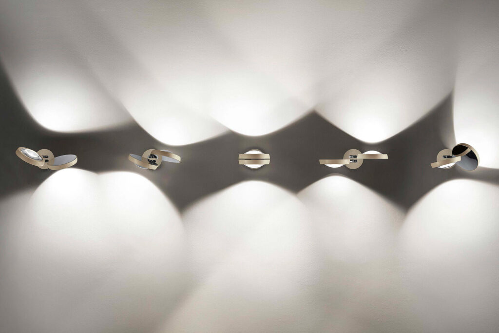 Row of Lodes Nautilus double wall lights washing light up and down a long grey wall