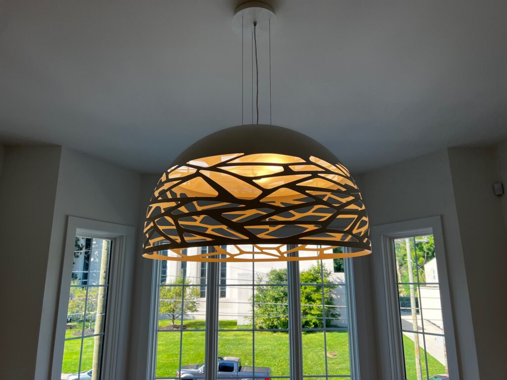 Lodes Kelly dome pendant in bronze glowing over a breakfast table