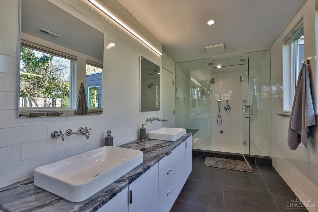 PureEdge Lighting Cirrus linear LED light running along the wall above a double vanity with vessel sinks in a modern white bathroom