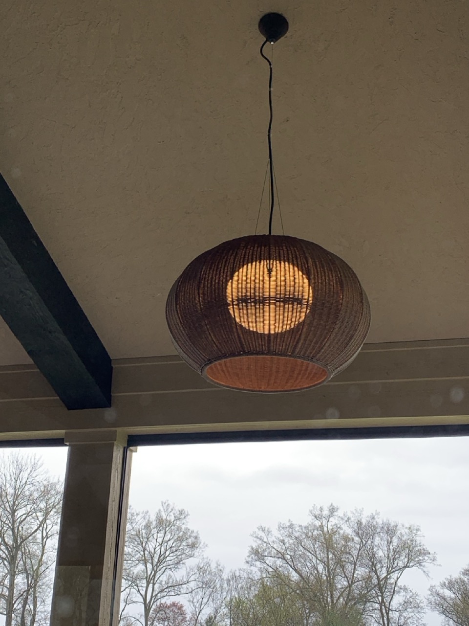 Bover Garota pendant glowing under a beamed ceiling