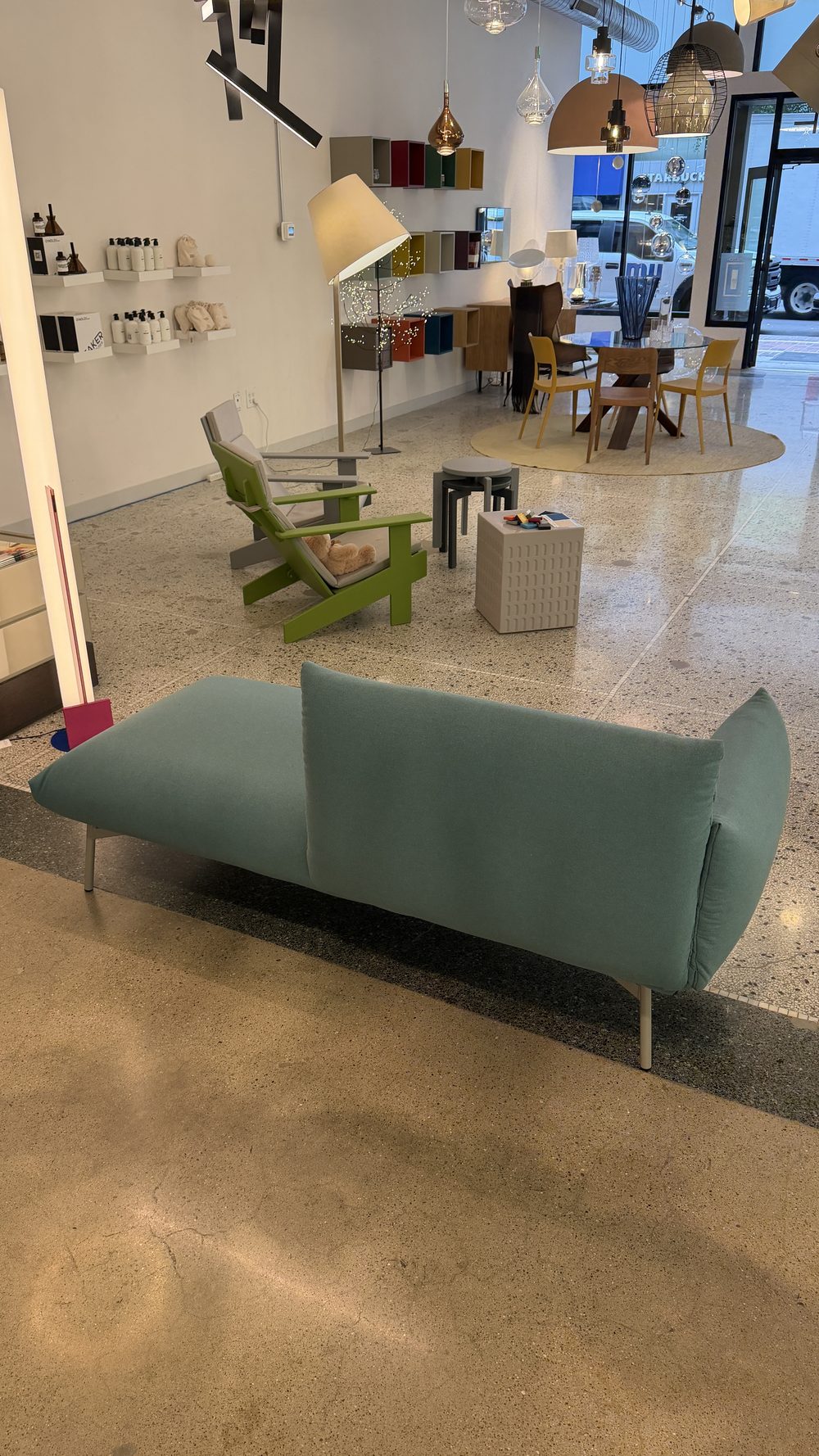 The Midj Area Chaise in the Switch Lighting & Design showroom, with pendant lights and furniture beyond