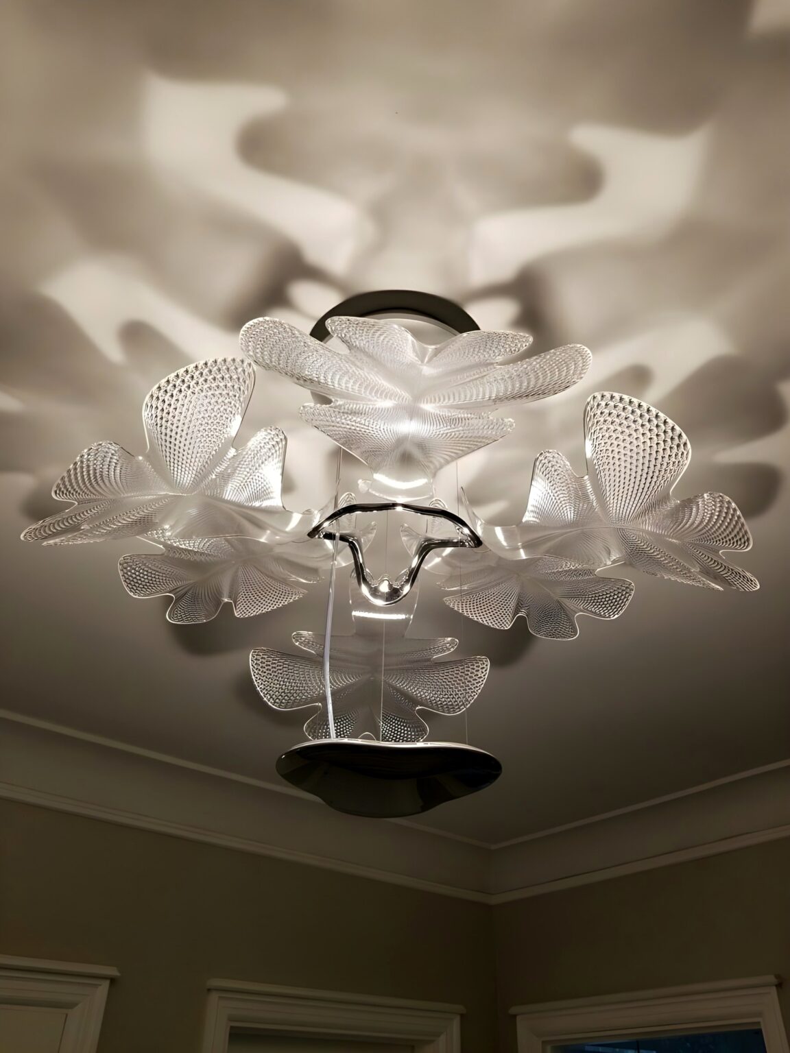 Artemide Chlorophilia ceiling light casting leaf shadows