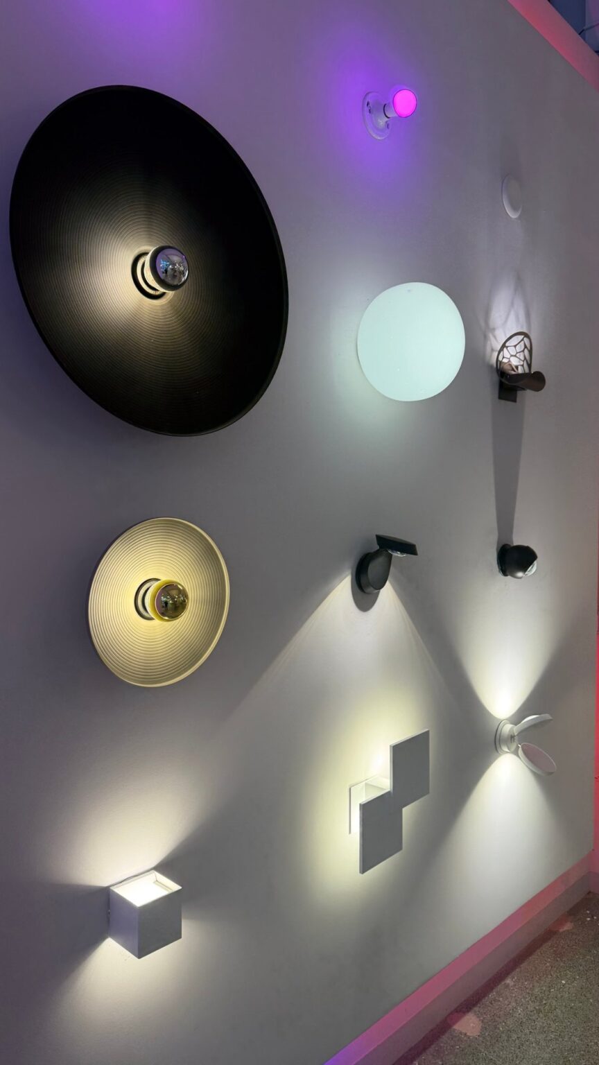 Black Diesel Living with Lodes Vinyl disc wall lights, round shades glowing at their edges against a wall