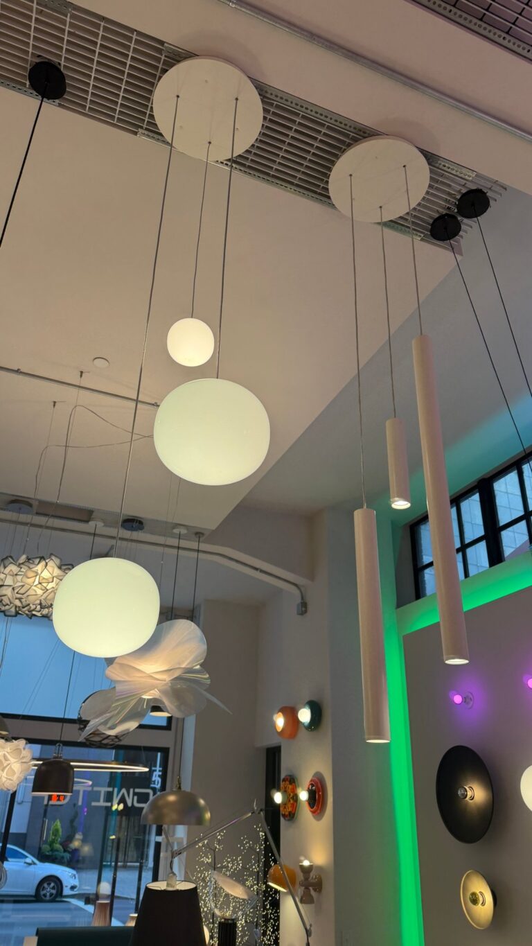 White A-Tube pendants sharing round canopies with Volum glass globes in the Switch showroom