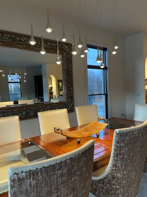 Rain pendants over a dining table with a carved mirror