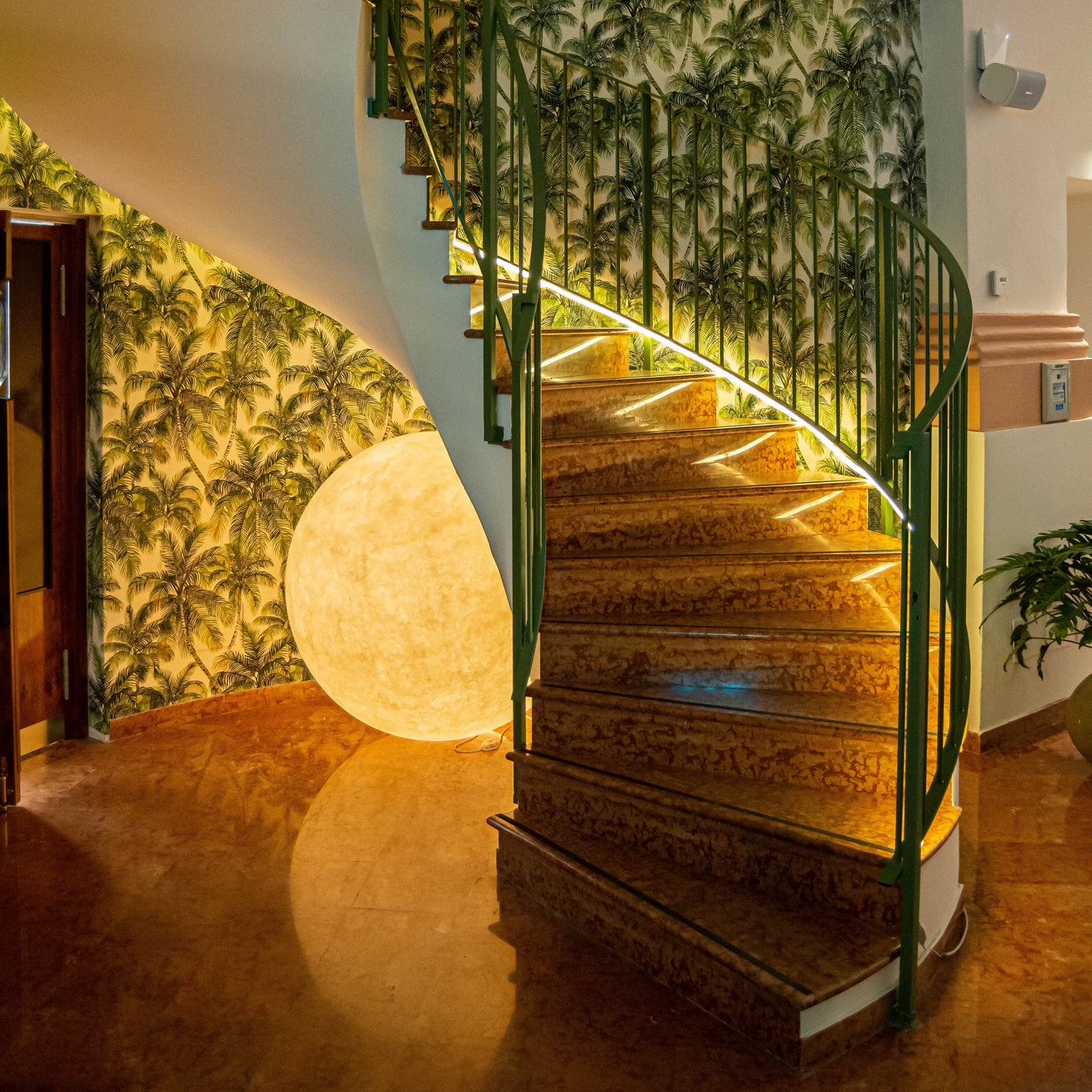 Large Moon floor lamp in Nebulite glowing at the foot of a spiral staircase