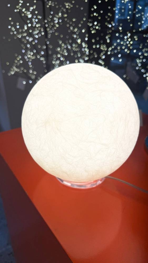 Uplight Group Moon lamp made of Nebulite glowing on an orange pedestal at Switch Lighting & Design